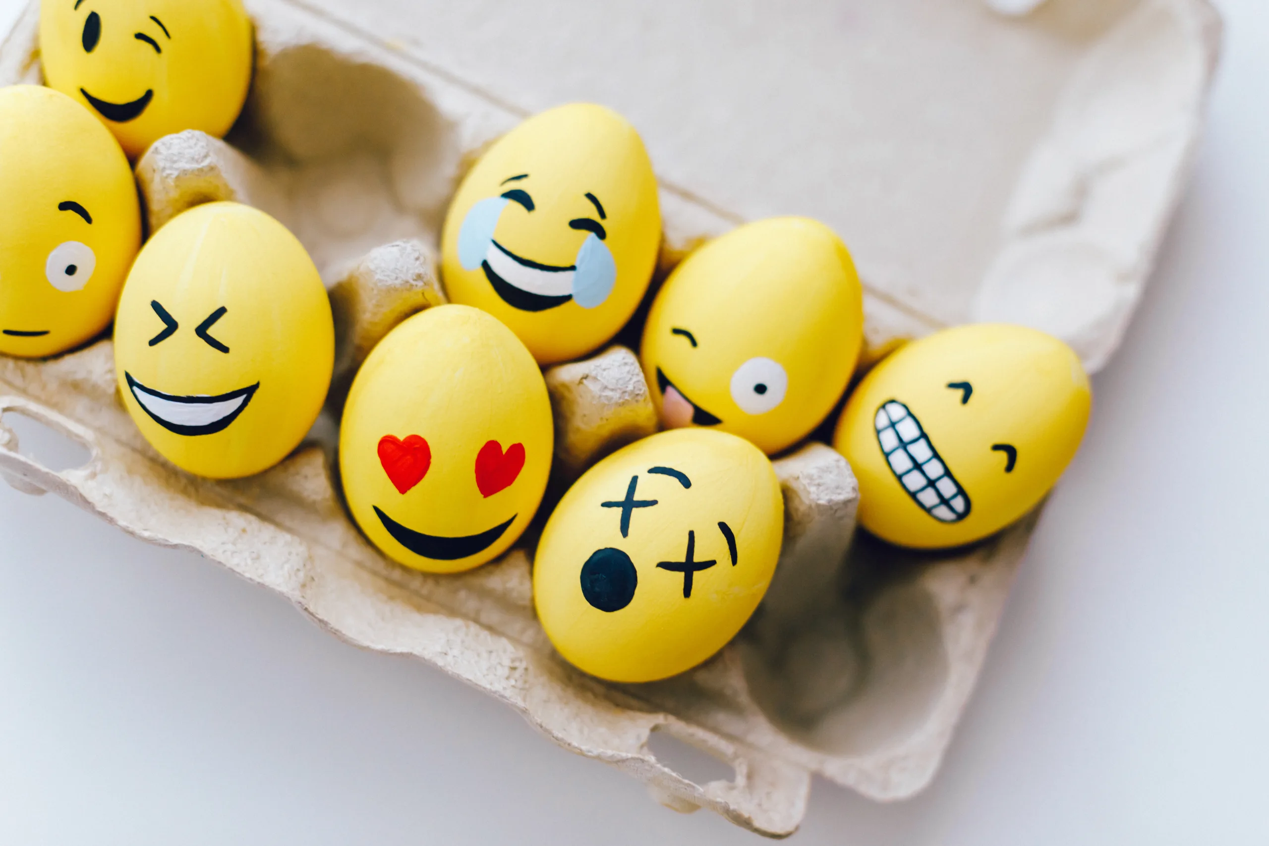 Yellow painted eggs with various facial expressions