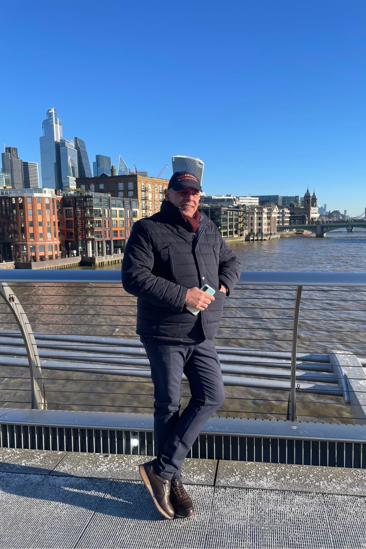 Αντρας πάνω στην Millenial Bridge και φόντο το City of London 